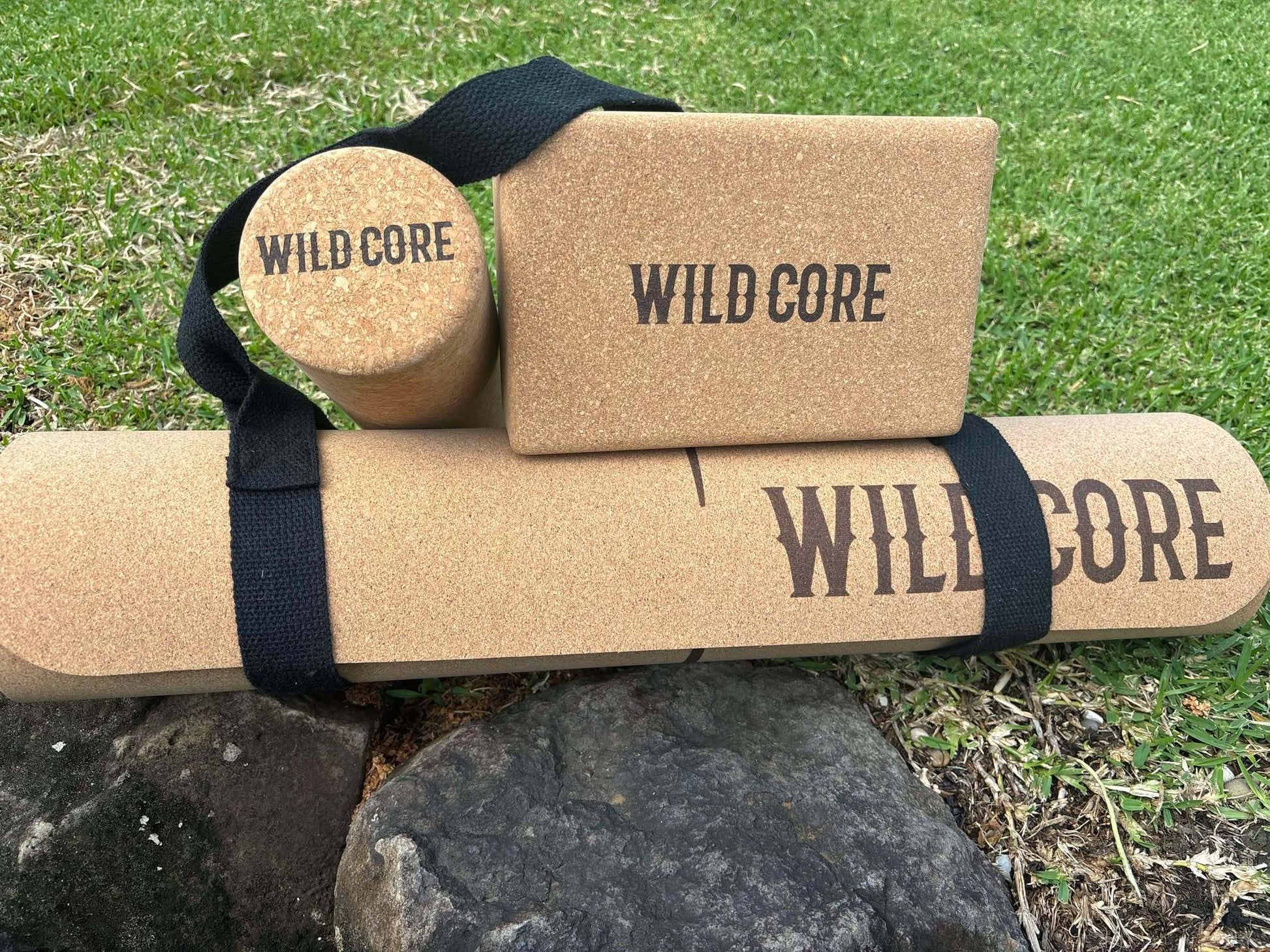Wild Core Premium Cork Yoga Mat bundle with massage roller and yoga block on grass outdoors
