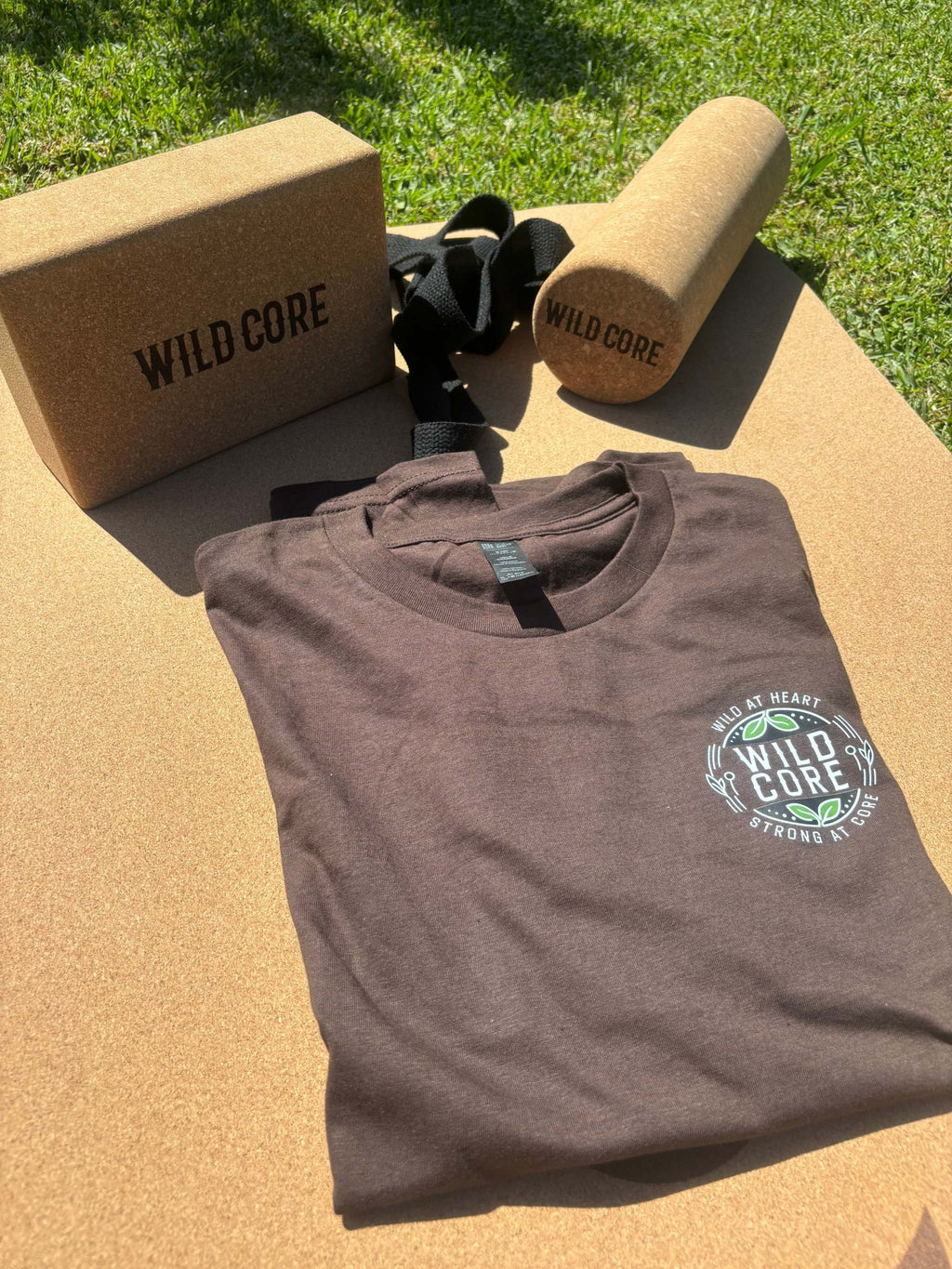 Wild Core Full Set featuring eco-friendly premium cork yoga mat, cork massage roller, cork yoga block, and organic cotton t-shirt on grass background