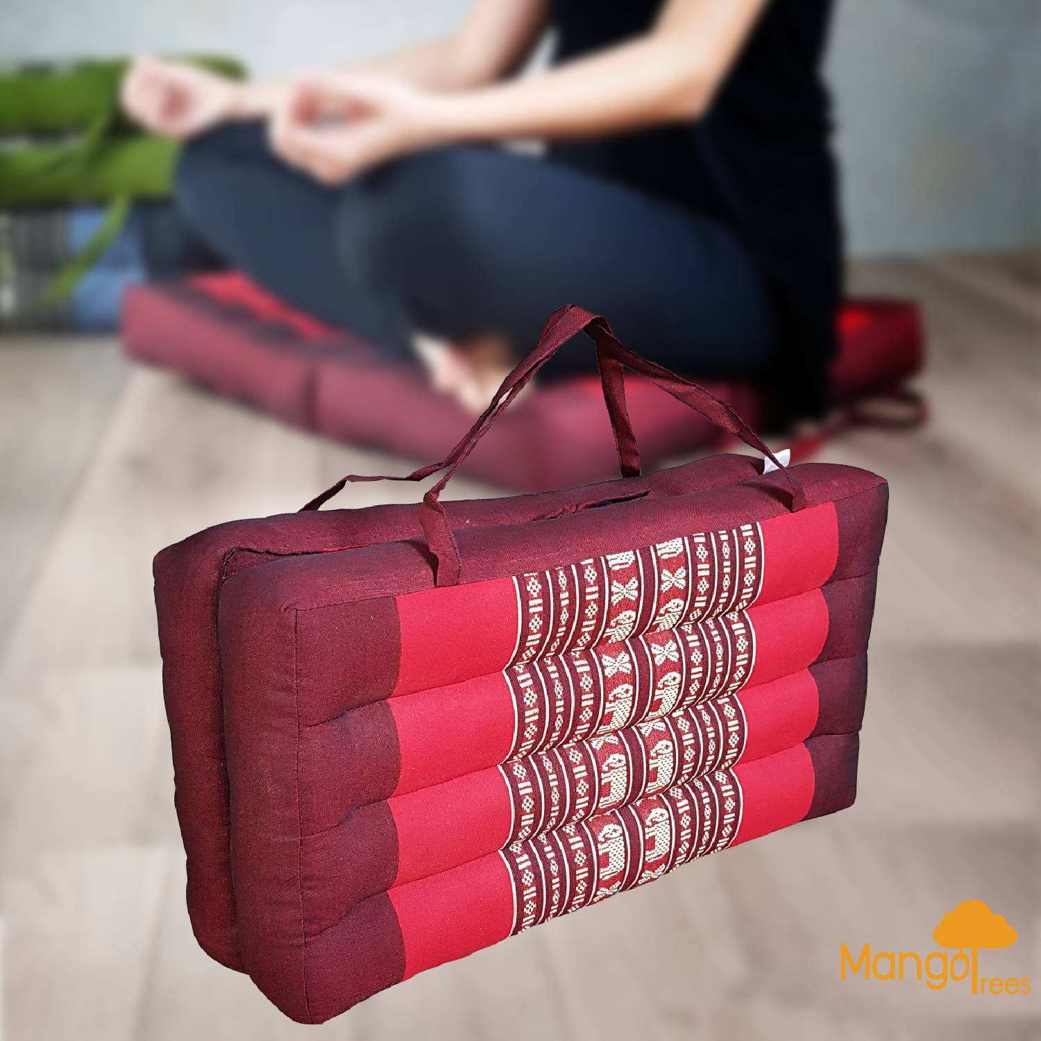 Foldable red meditation cushion with organic kapok filling and carrying handle, used for yoga and seating support.