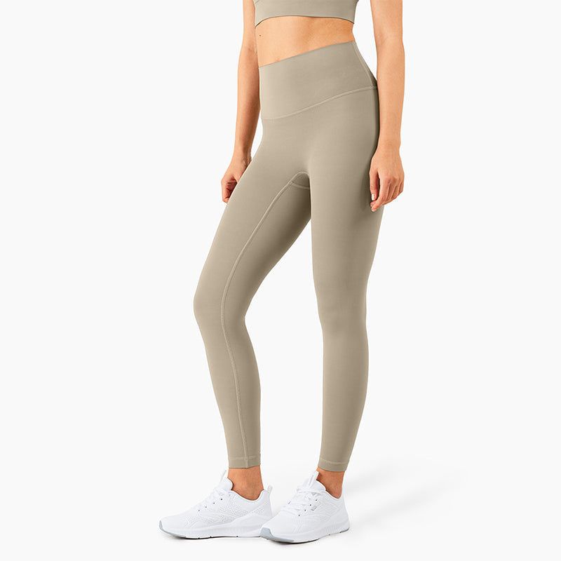 Woman wearing size S khaki high-waisted seamless yoga pants with tummy control and butt lifting features, paired with white sneakers.