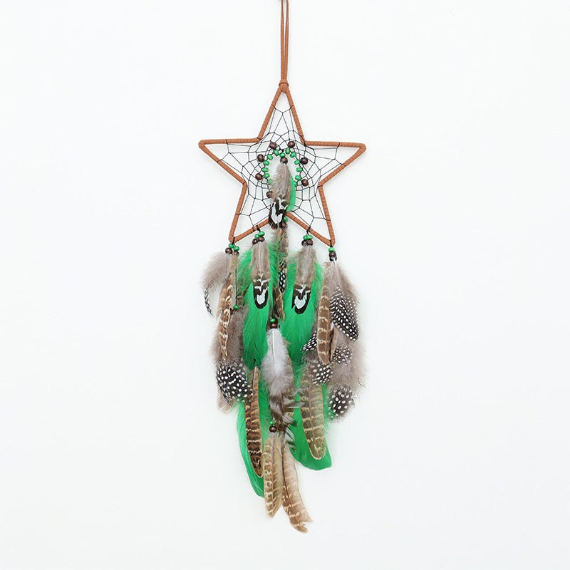 Star-shaped boho forest dreamcatcher with green and natural feathers hanging on a leather cord