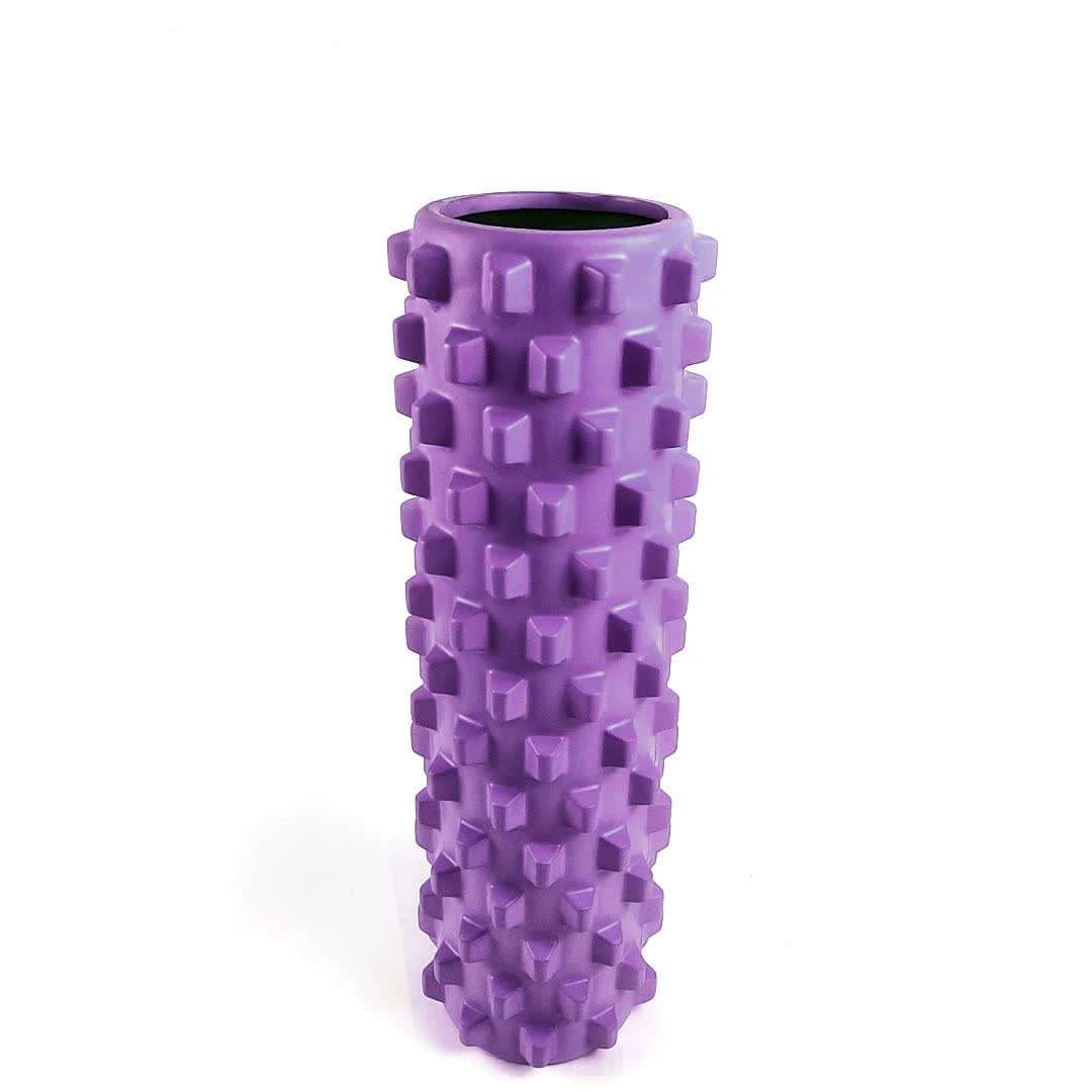 Purple solid yoga foam roller with textured wolf tooth design for muscle massage and relaxation.