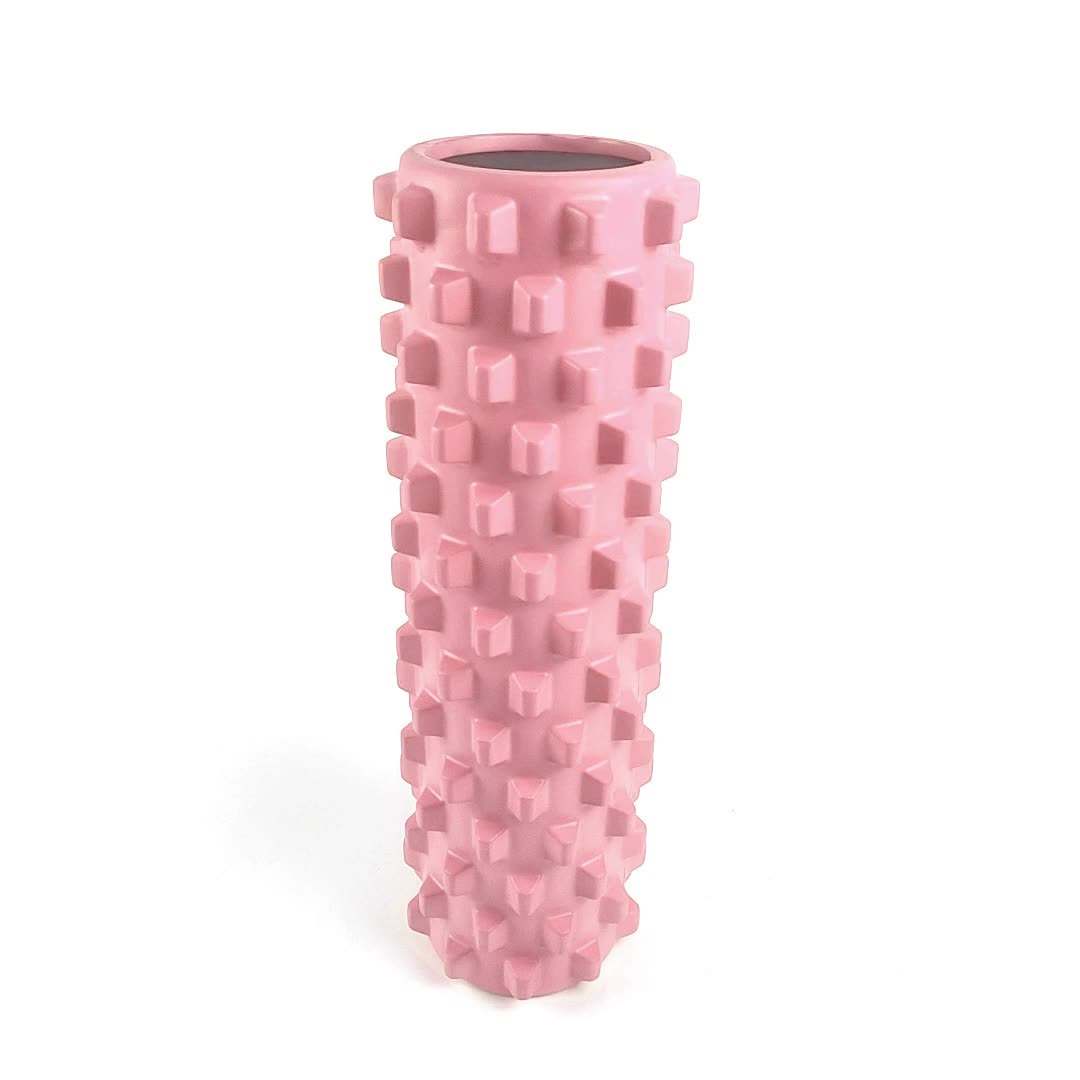 Pink solid yoga foam roller with textured wolf tooth design for muscle relaxation and massage.