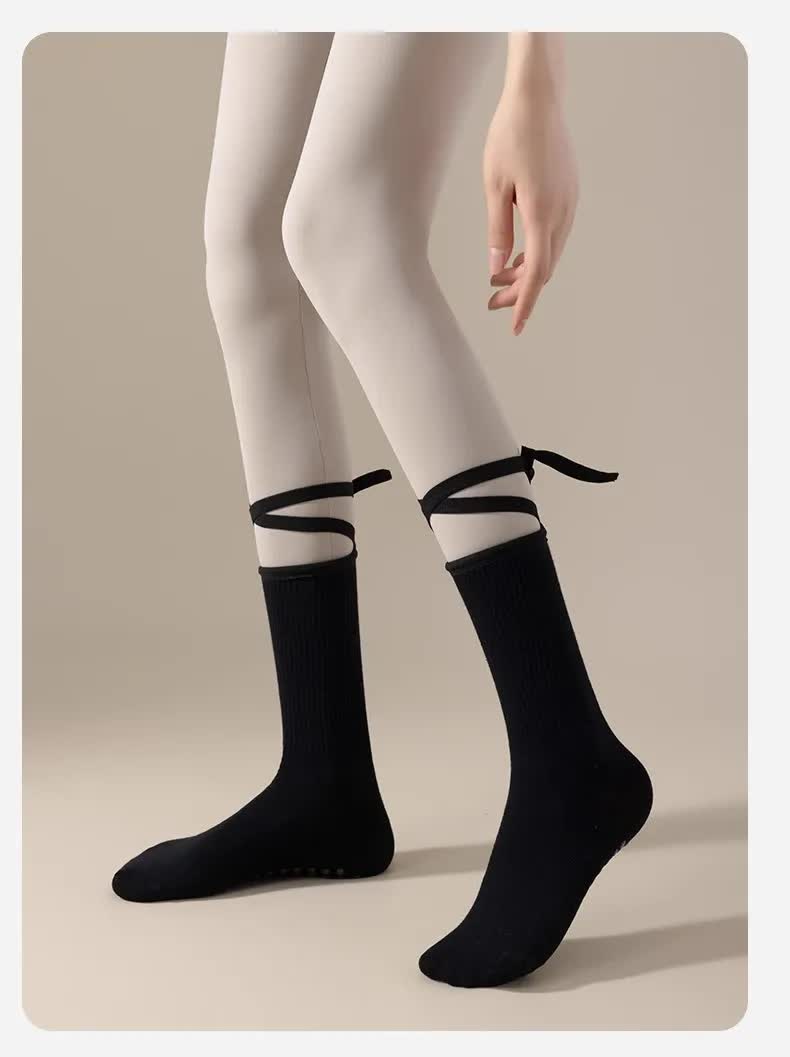 Black non-slip yoga socks with cross straps for women, lightweight cotton Pilates and dance socks providing grip and comfort.