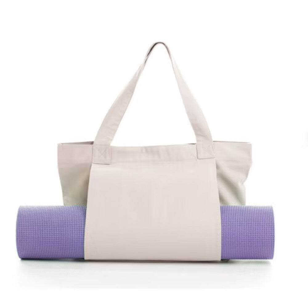 Khaki canvas yoga mat tote bag with side pocket carrying a purple rolled yoga mat for outdoor workouts and travel
