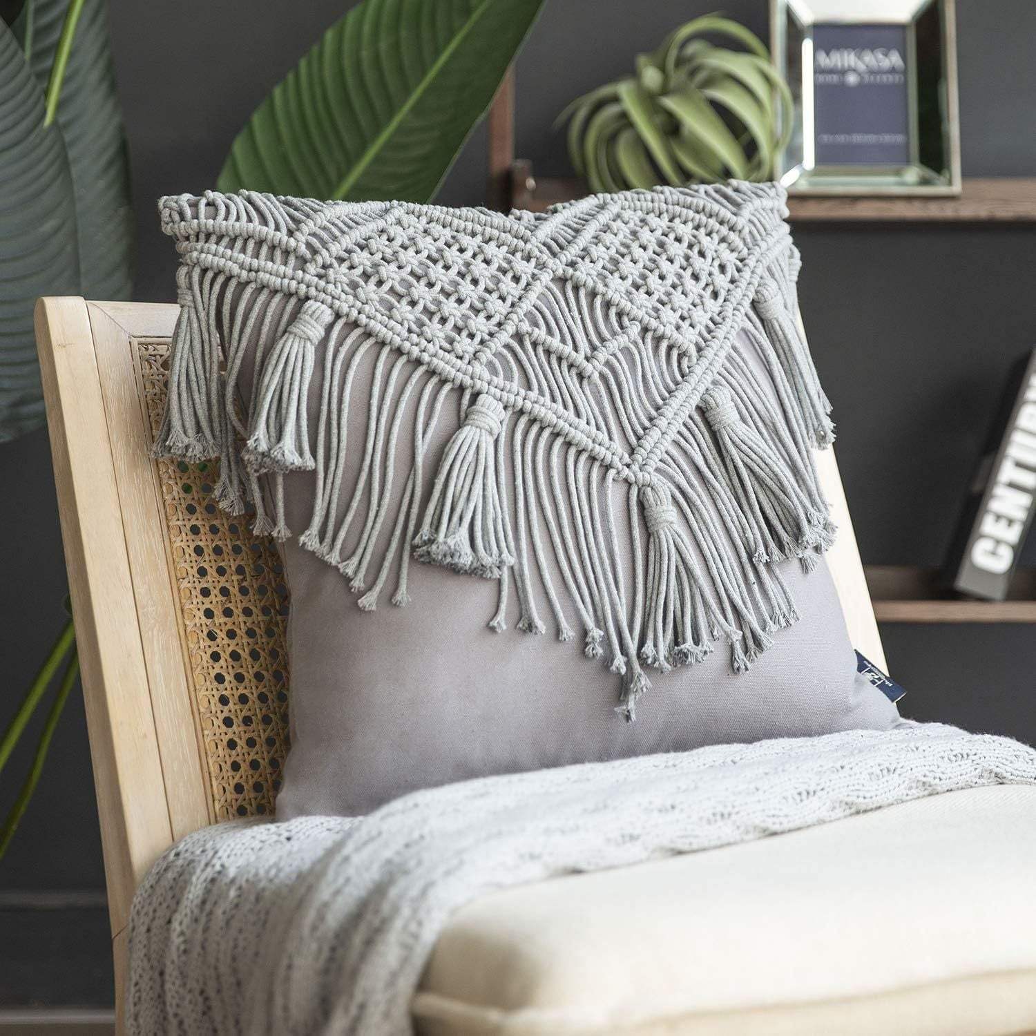 Grey boho chic macrame cushion cover with handmade woven cotton linen fabric and tassels on chair